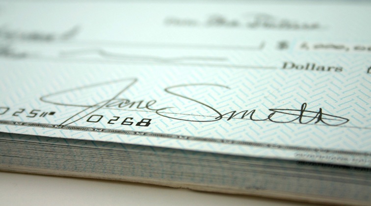 Zoomed in angle of a light blue checkbook filled out with the name Jane Smith.